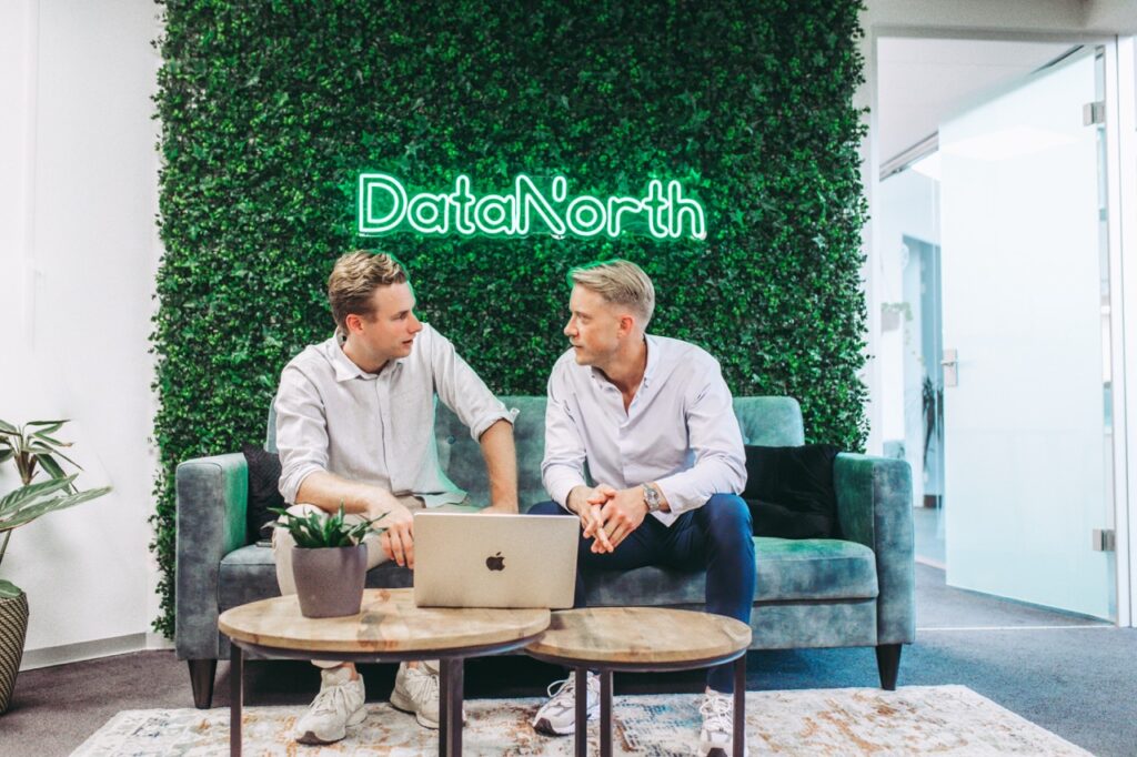 Nick and Menno in front of the DN logo